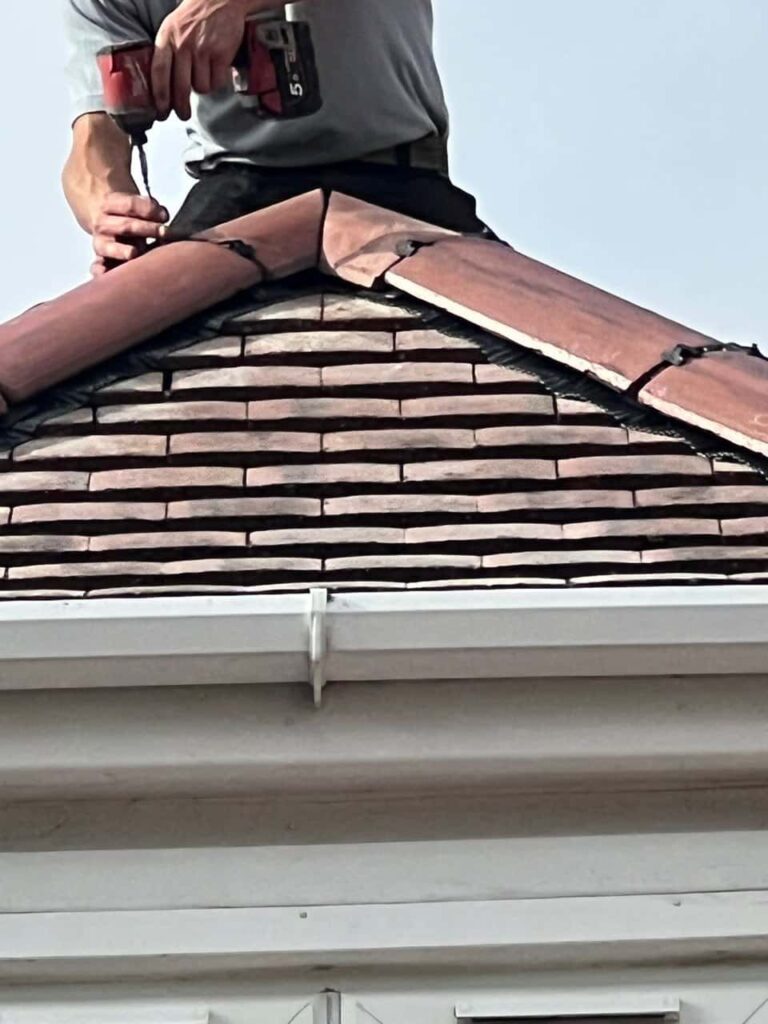 This is a photo of one of the operatives of Ruddington Roofing Repairs installing new ridge tiles